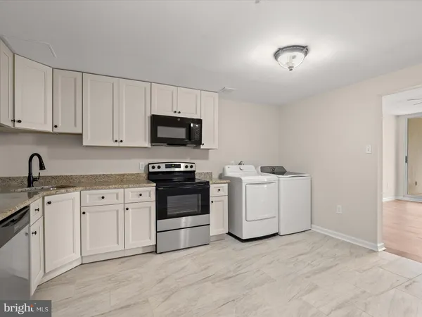 a kitchen with appliances a sink and cabinets