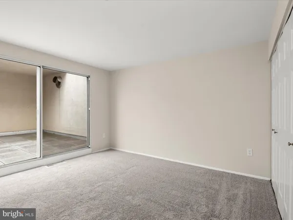 an empty room with sliding glass door and shower