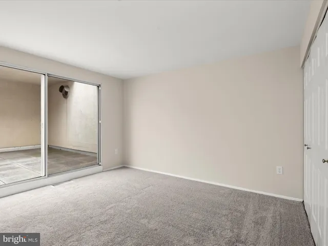 an empty room with sliding glass door and shower
