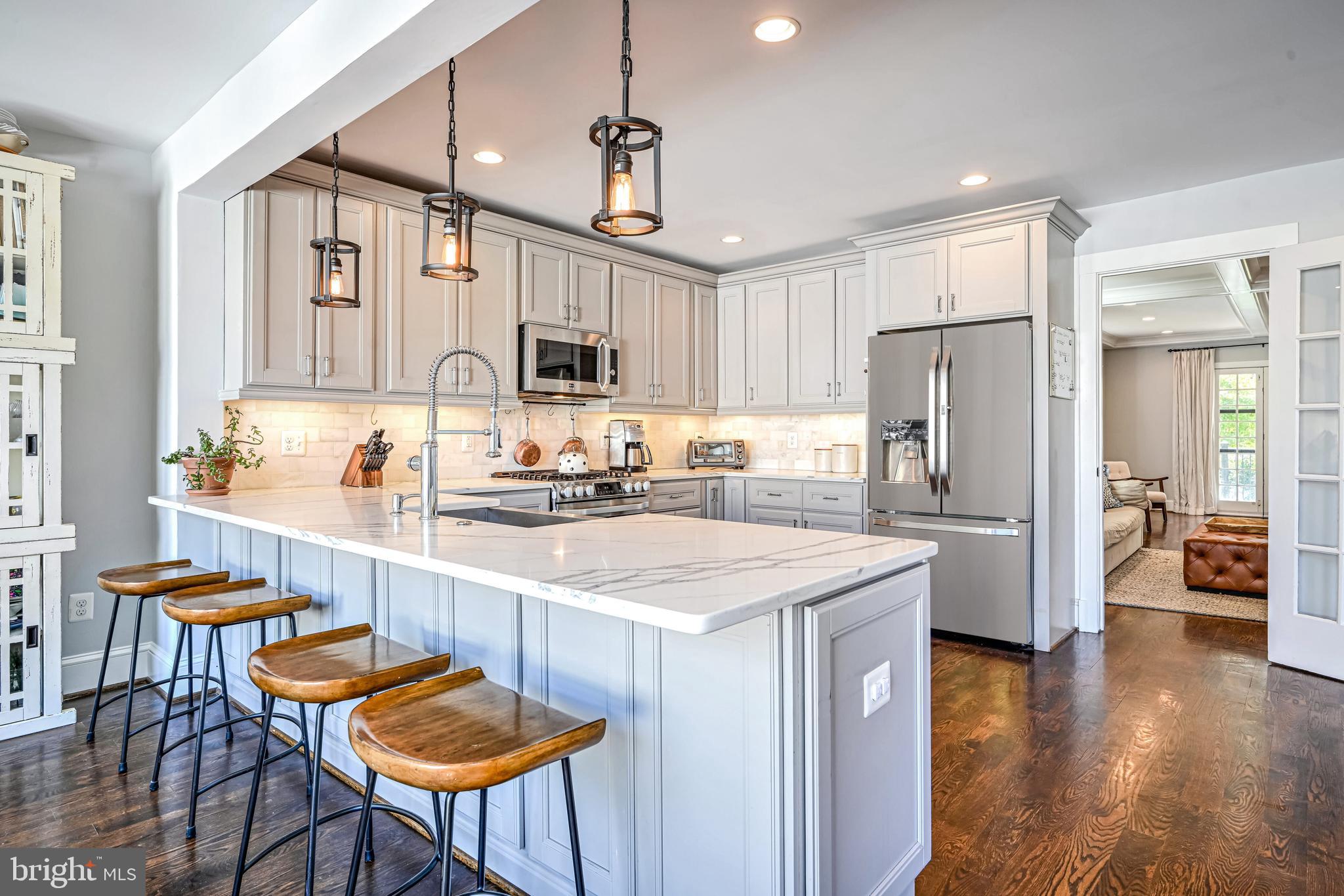 1507 Decatur Street Northwest Washington, DC 20011 - Photo 9 of 30 a kitchen with stainless steel appliances granite countertop a refrigerator a stove a sink a dining table and chairs with wooden floor