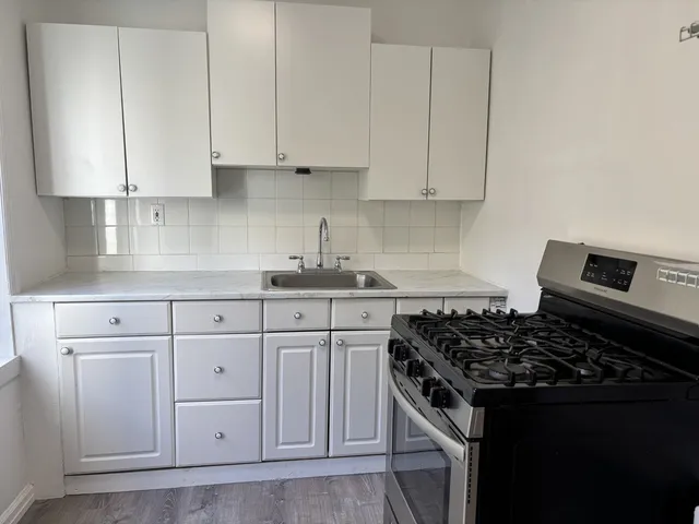 a kitchen with white cabinets and appliances