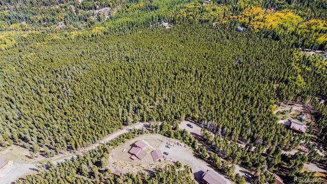 a view of a lush green forest with mountains in the background
