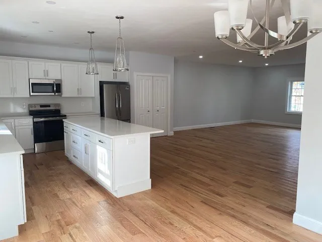 a kitchen with stainless steel appliances granite countertop a stove top oven a refrigerator a sink and dishwasher