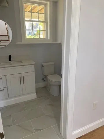 a bathroom with a toilet sink and window