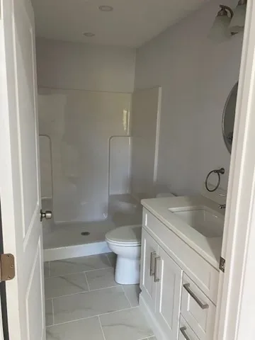 a bathroom with a sink a toilet and shower