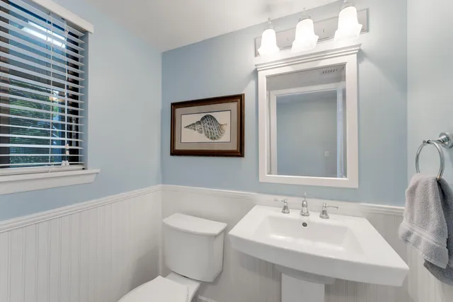 a bathroom with a toilet sink and mirror