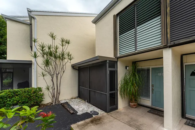 a backyard of a house with potted plants and a table