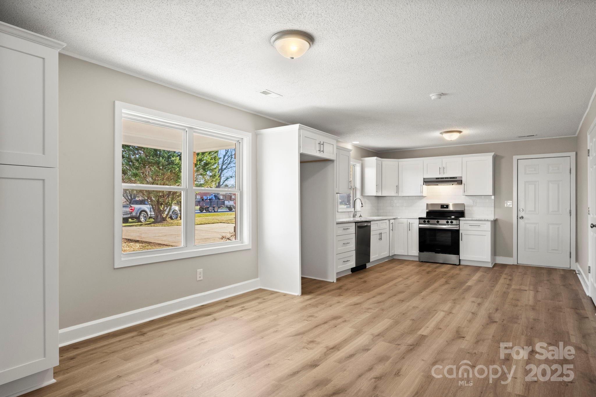 1421 North Post Road Shelby, NC 28150 - Photo 14 of 34 a kitchen with granite countertop white cabinets and stainless steel appliances