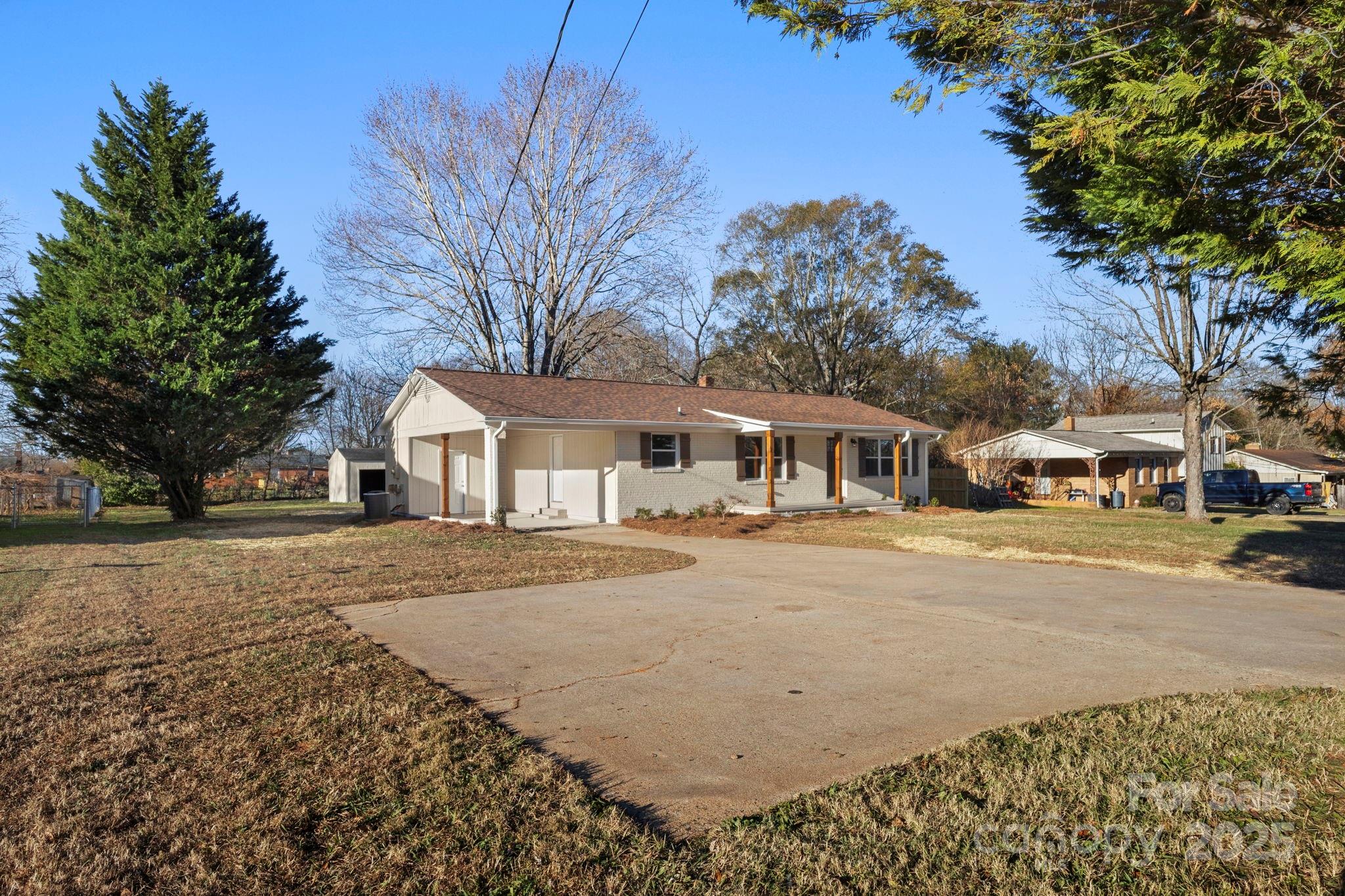 1421 North Post Road Shelby, NC 28150 - Photo 3 of 34 a front view of a house with a yard covered with trees