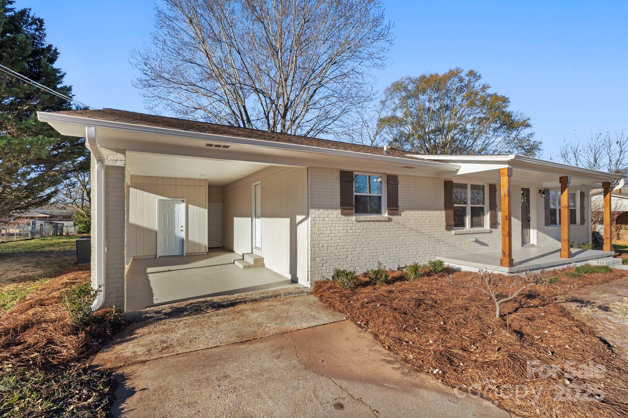 1421 North Post Road Shelby, NC 28150 - Photo 4 of 34 a front view of a house with a yard and potted plants