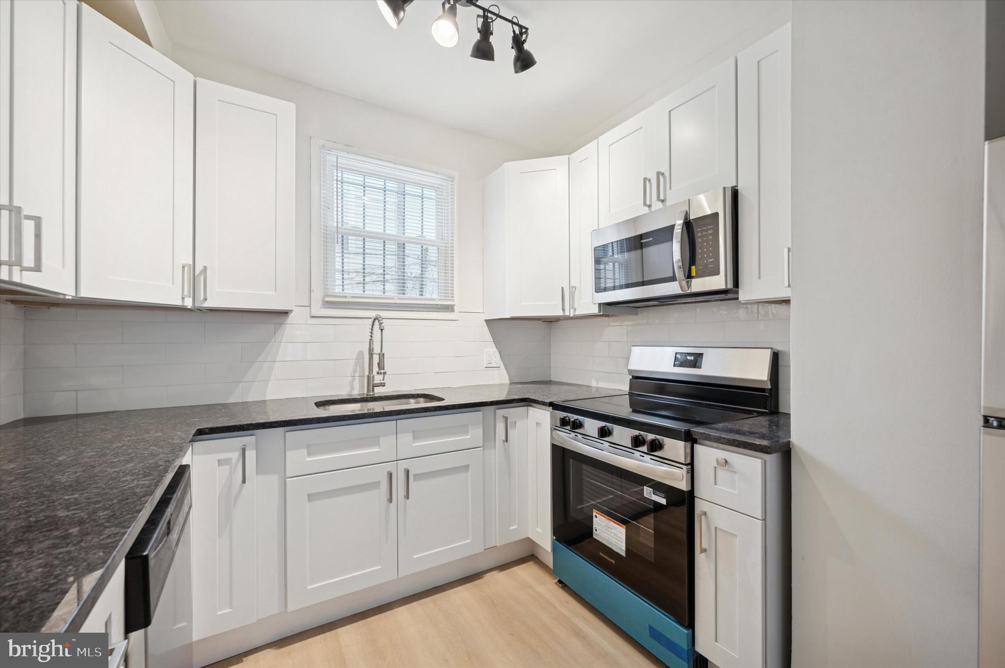 2457 North Patton Street Philadelphia, PA 19132 - Photo 11 of 23 a kitchen with white cabinets stainless steel appliances and a sink