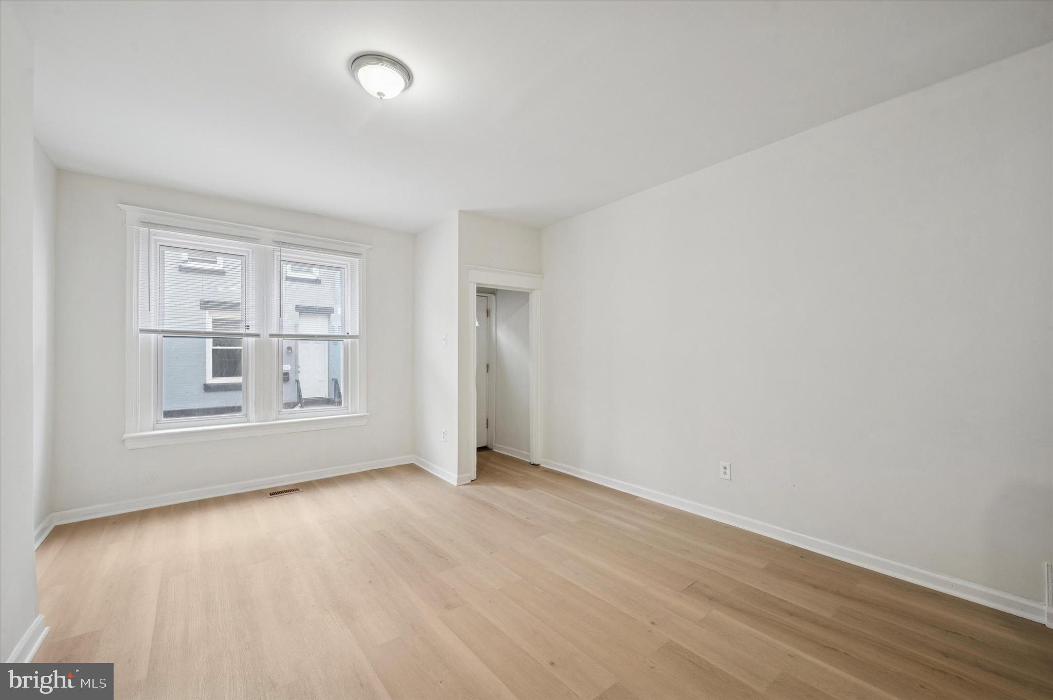 2457 North Patton Street Philadelphia, PA 19132 - Photo 5 of 23 an empty room with wooden floor and windows