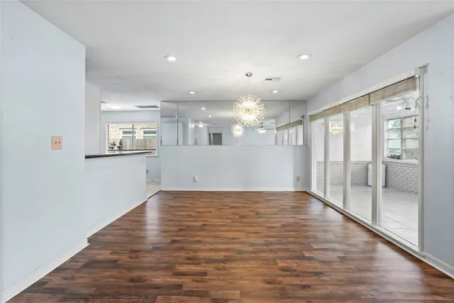 a view of a big room with wooden floor and windows
