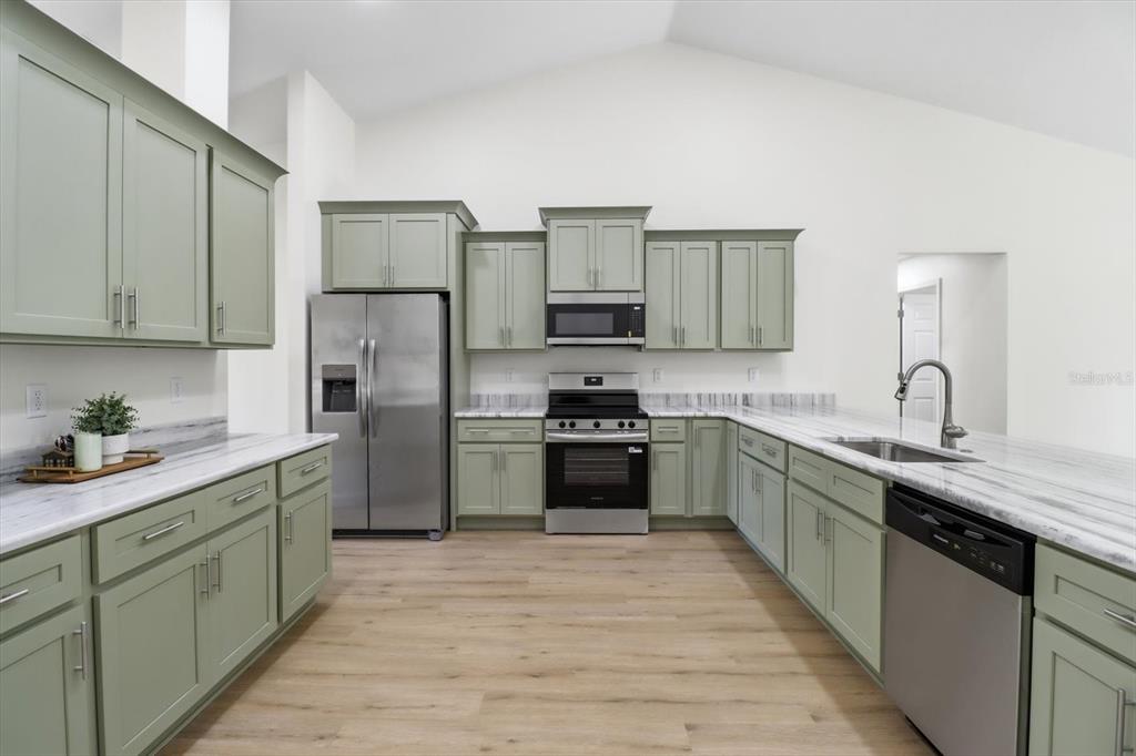 13418 Cormorant Road Weeki Wachee, FL 34614 - Photo 15 of 46 a kitchen with stainless steel appliances granite countertop a sink stove and refrigerator