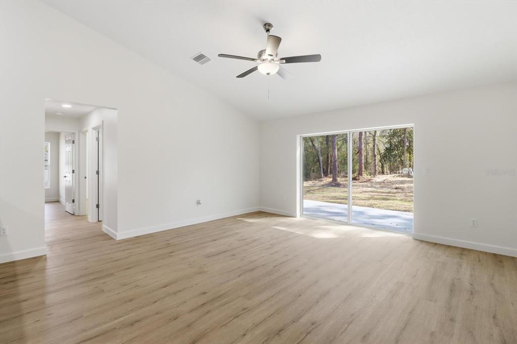 13418 Cormorant Road Weeki Wachee, FL 34614 - Photo 19 of 46 a view of an empty room with wooden floor and a window