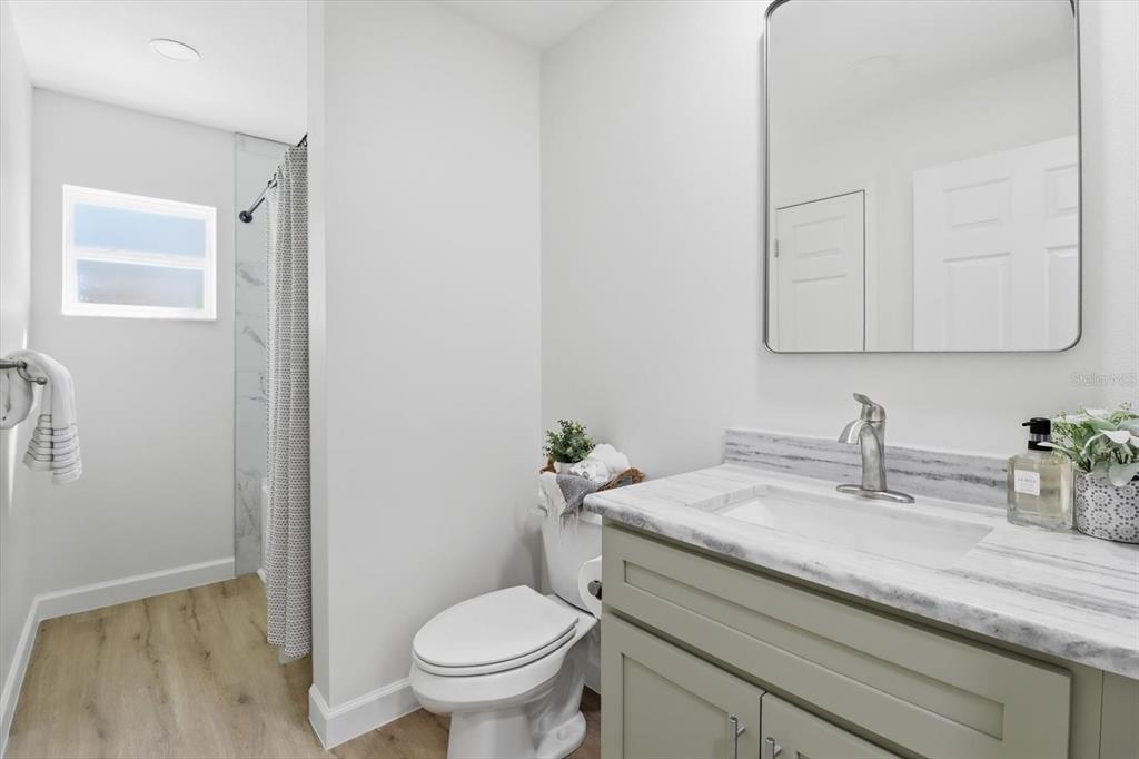 13418 Cormorant Road Weeki Wachee, FL 34614 - Photo 26 of 46 a bathroom with a granite countertop toilet sink and mirror
