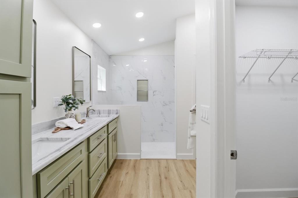 13418 Cormorant Road Weeki Wachee, FL 34614 - Photo 32 of 46 a spacious bathroom with a granite countertop sink and a mirror