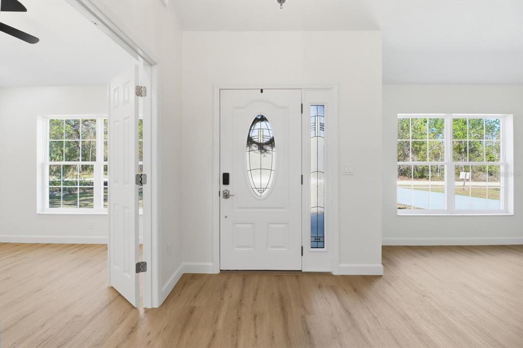 13418 Cormorant Road Weeki Wachee, FL 34614 - Photo 7 of 46 an empty room with wooden floor and windows