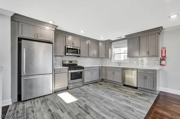 a kitchen with granite countertop a refrigerator stove and sink