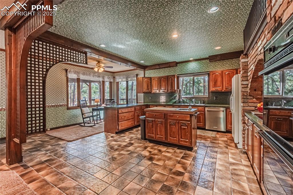 7190 Burgess Road Colorado Springs, CO 80908 - Photo 19 of 50 a large kitchen with stainless steel appliances and large cabinets
