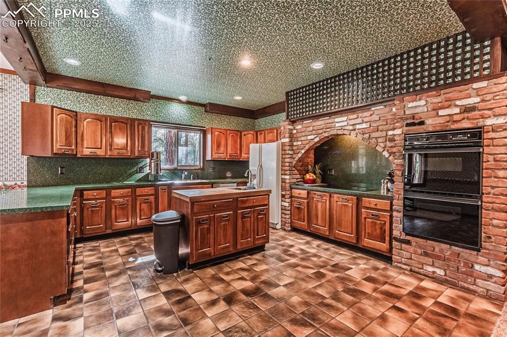 7190 Burgess Road Colorado Springs, CO 80908 - Photo 20 of 50 a kitchen with stainless steel appliances granite countertop a stove a sink and a microwave