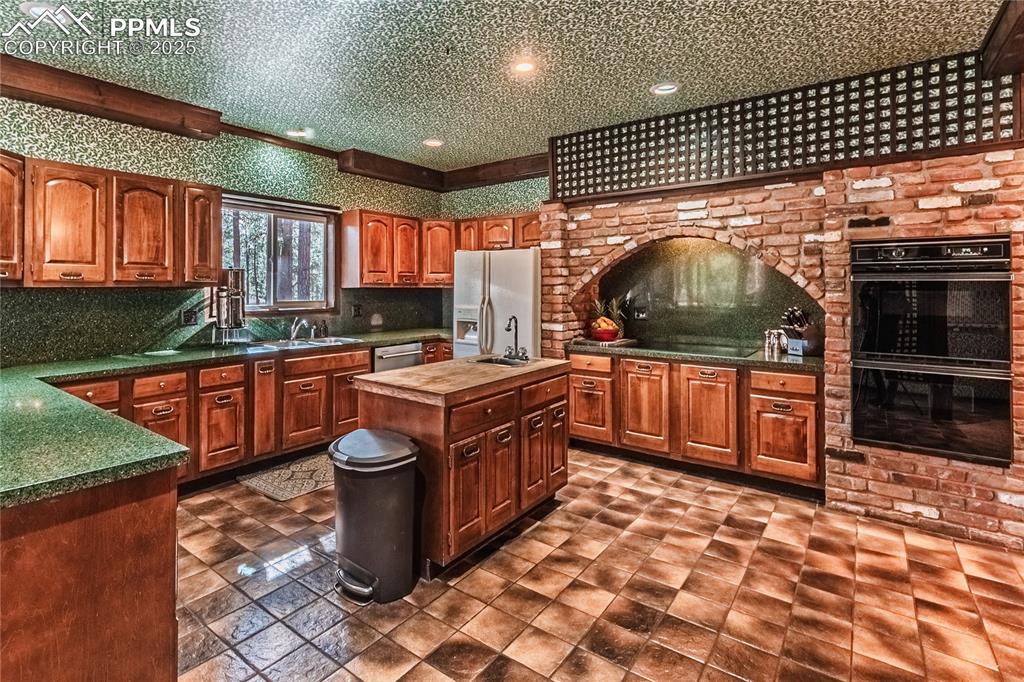 7190 Burgess Road Colorado Springs, CO 80908 - Photo 23 of 50 a kitchen with stainless steel appliances kitchen island granite countertop a sink and cabinets