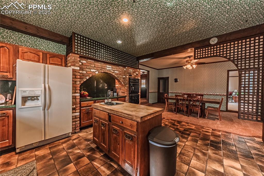 7190 Burgess Road Colorado Springs, CO 80908 - Photo 25 of 50 a kitchen with stainless steel appliances granite countertop a sink a stove and a refrigerator