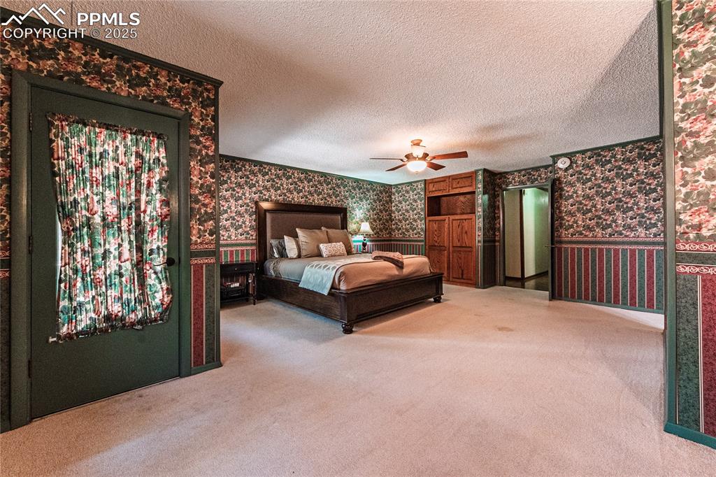 7190 Burgess Road Colorado Springs, CO 80908 - Photo 36 of 50 a bed room with a bed and a couch