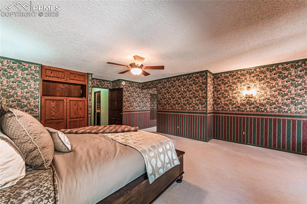 7190 Burgess Road Colorado Springs, CO 80908 - Photo 37 of 50 a bedroom with a large bed and a chandelier