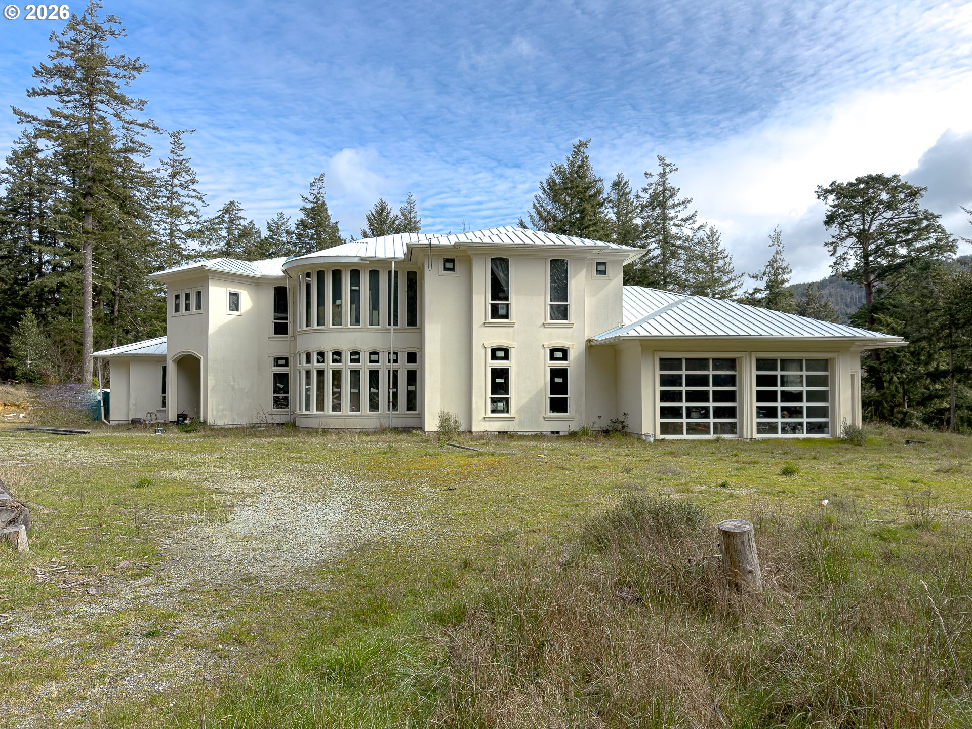 46914 Highway 101 Bandon, OR 97411 - Photo 37 of 48 a view of a big house with a big yard and large trees