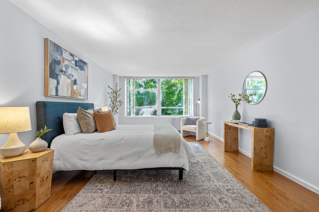 80 Park Street, Unit 23 Brookline, MA 02446 - Photo 27 of 38 a bedroom with a bed wooden floor and window
