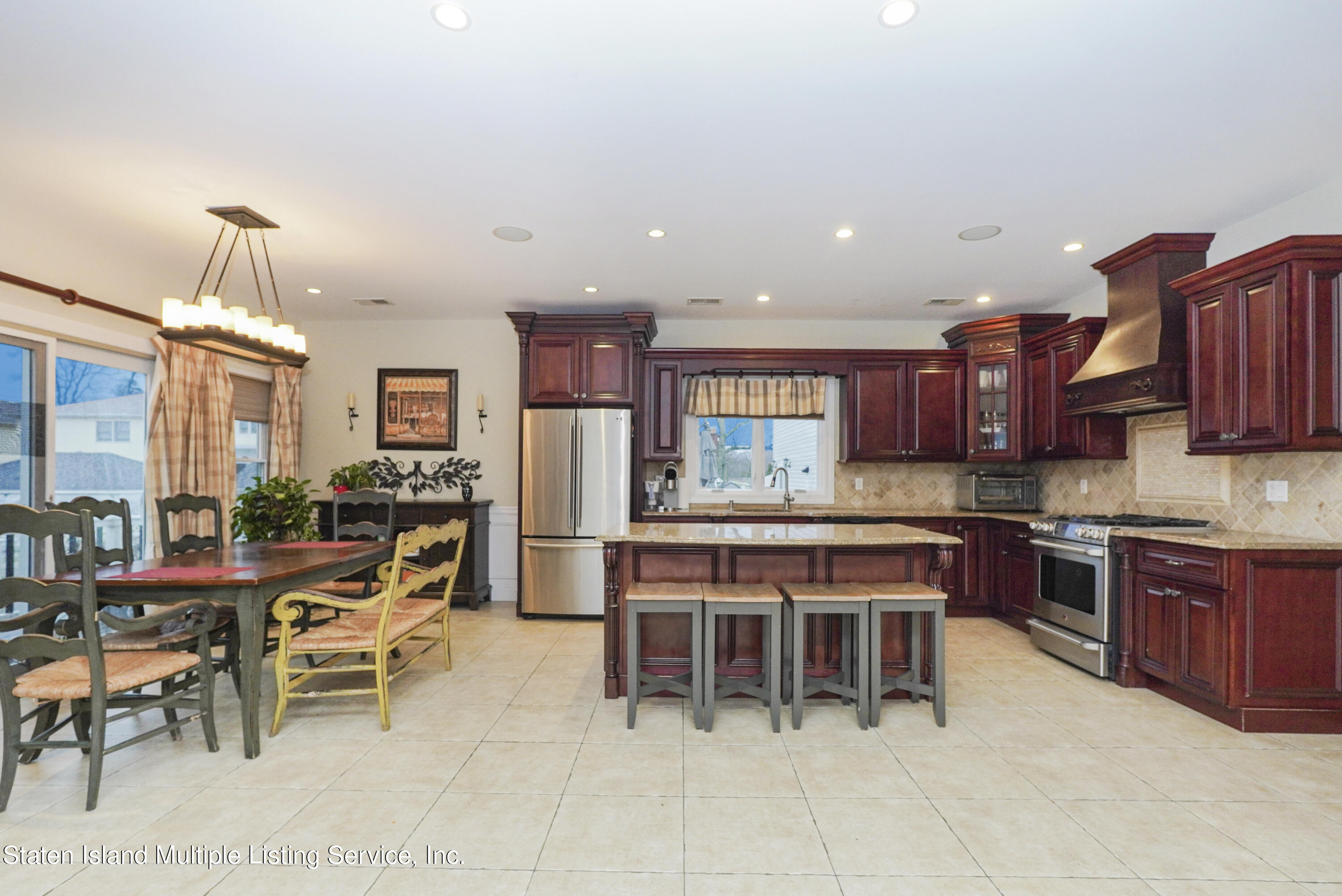 20 Kenneth Place Staten Island, NY 10309 - Photo 15 of 52 a kitchen with stainless steel appliances kitchen island granite countertop a table chairs sink and cabinets