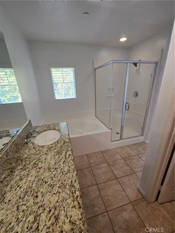 a bathroom with a granite countertop sink a mirror and a shower