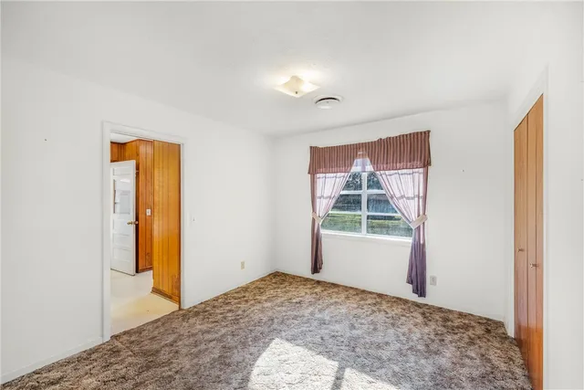 a view of a room that has a bed and a window