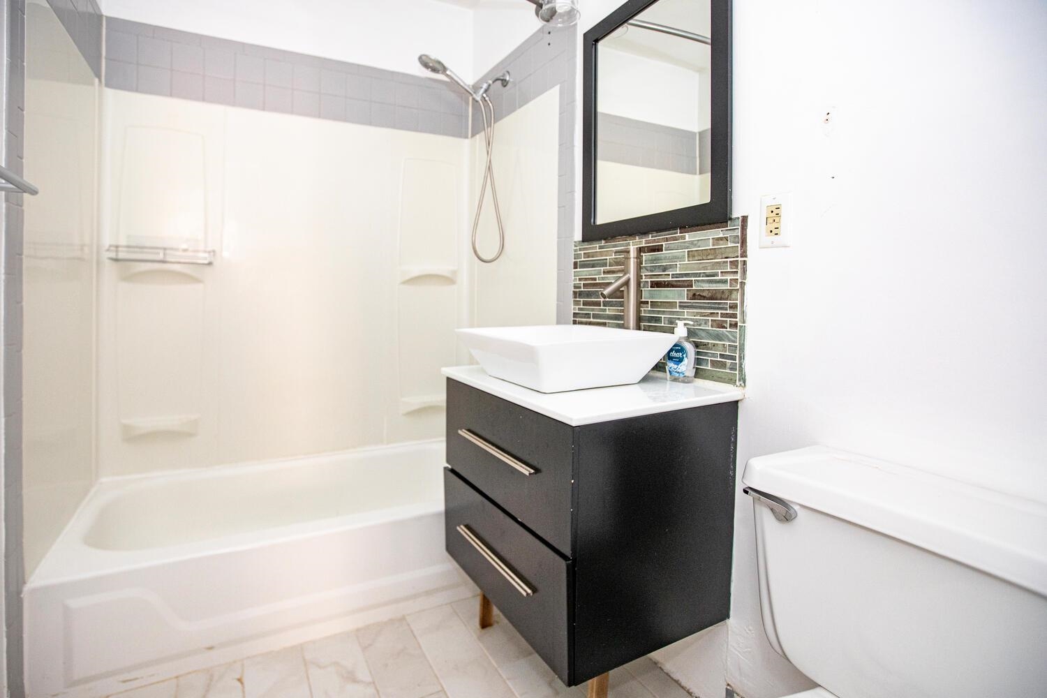 341 Monmouth Street, Unit 203D Jersey City, NJ 07302 - Photo 12 of 23 a bathroom with a sink a toilet and a bathtub