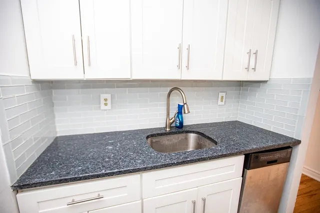 a kitchen with granite countertop a sink and cabinets