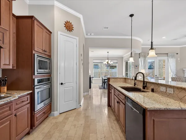 a kitchen with stainless steel appliances granite countertop a sink and a refrigerator