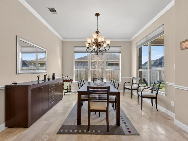 a view of a dining room with furniture a chandelier and wooden floor
