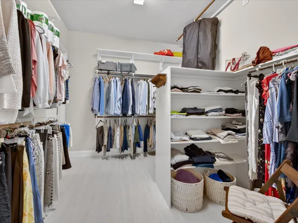 a view of walk in closet with clothes and shoes