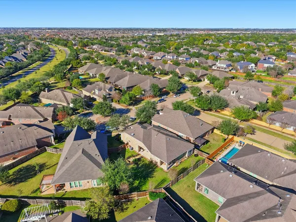 an aerial view of residential houses with outdoor space and swimming pool
