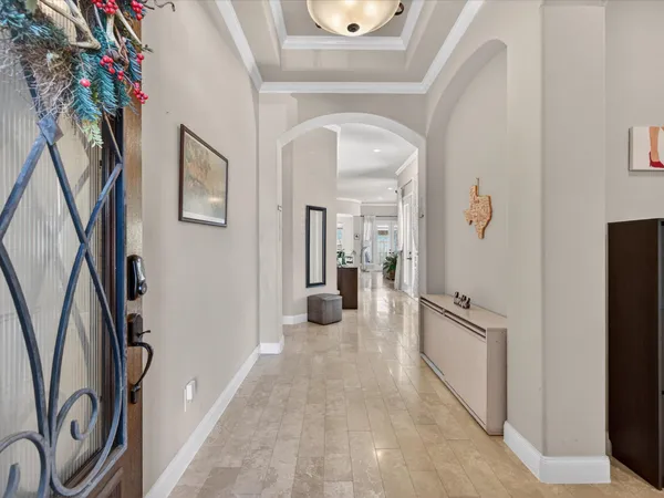 a view of a hallway with wooden floor and livingroom with furniture