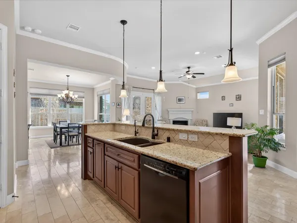 a kitchen with granite countertop a sink a counter top space and living room view