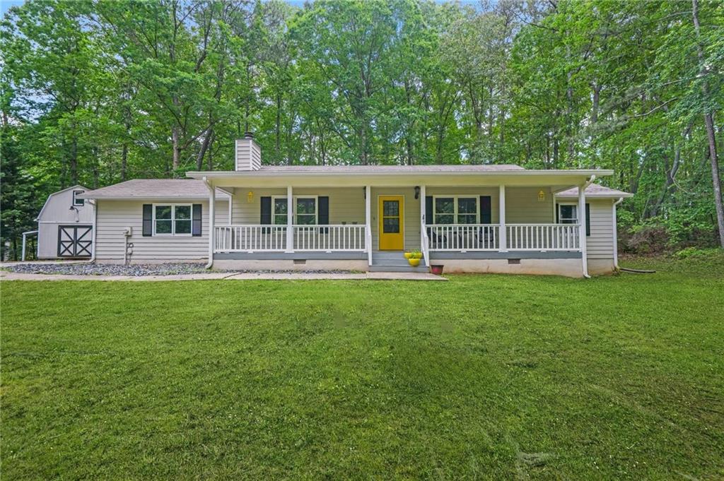 a front view of a house with a yard and green space