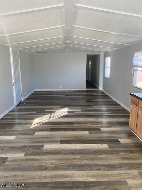 3941 State Road, Unit 48 Cuyahoga Falls, OH 44223 - Photo 3 of 8 Unfurnished living room with baseboards, vaulted ceiling with beams, and wood finished floors
