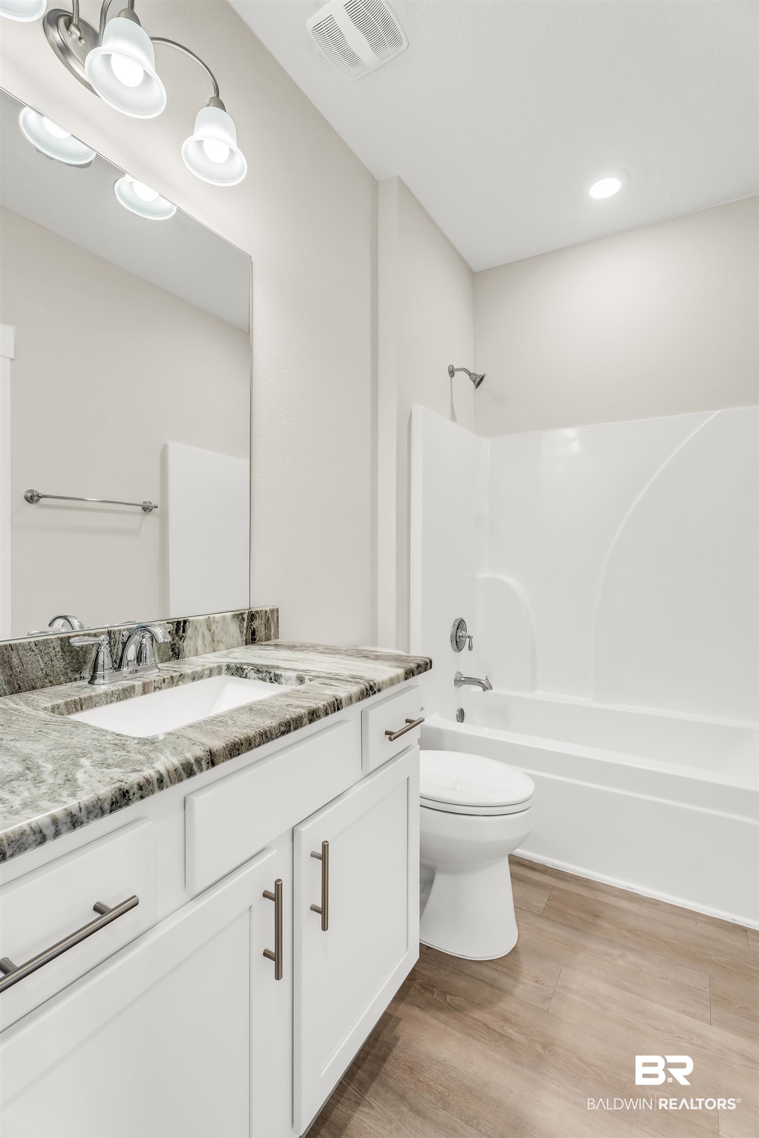 1720 Partridge Street Foley, AL 36535 - Photo 30 of 32 Full bathroom featuring toilet, hardwood / wood-style floors, vanity, and shower / washtub combination