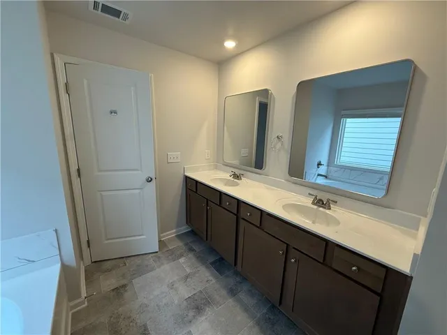 a bathroom with a double vanity sink a and mirror