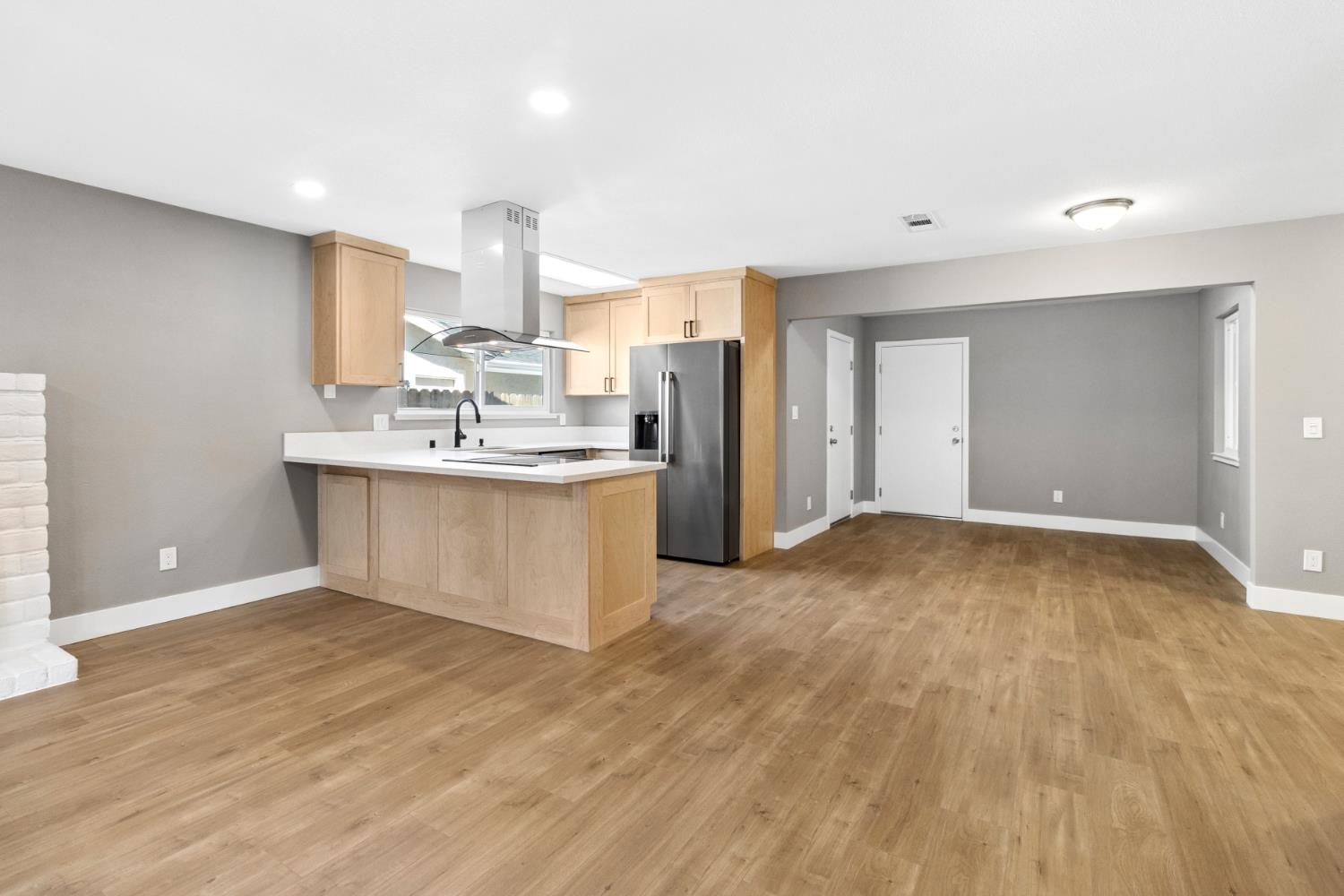 7249 Windjammer Way Citrus Heights, CA 95621 - Photo 10 of 41 a view of a kitchen with kitchen island a sink wooden floor and a refrigerator