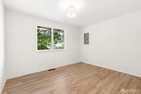 an empty room with wooden floor and windows