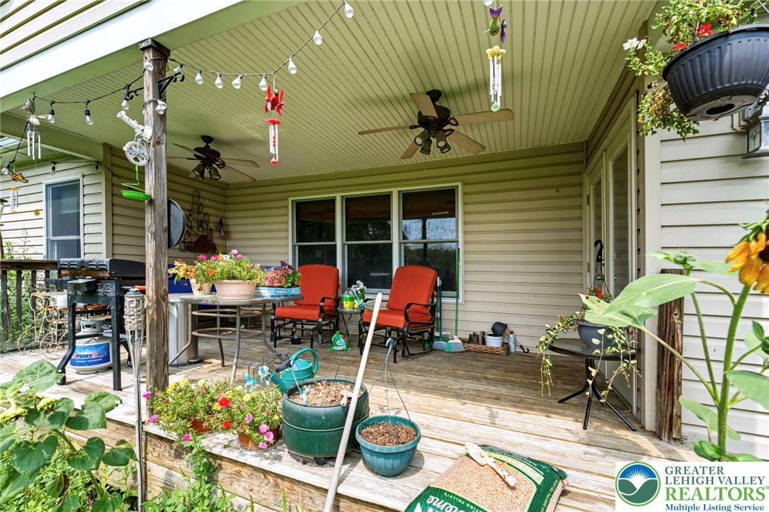 6970 Silver Crest Road Nazareth, PA 18064 - Photo 30 of 35 An inviting covered porch offers ample space for outdoor living, complete with comfortable seating and verdant potted plants.