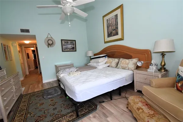 a bedroom with a bed and a lamp on dresser